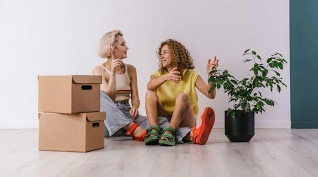 Two women sitting on the floor and talking